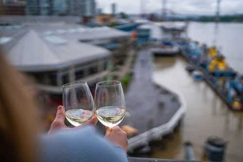 Couple on balcony looking over boardwalk with a glass of wine