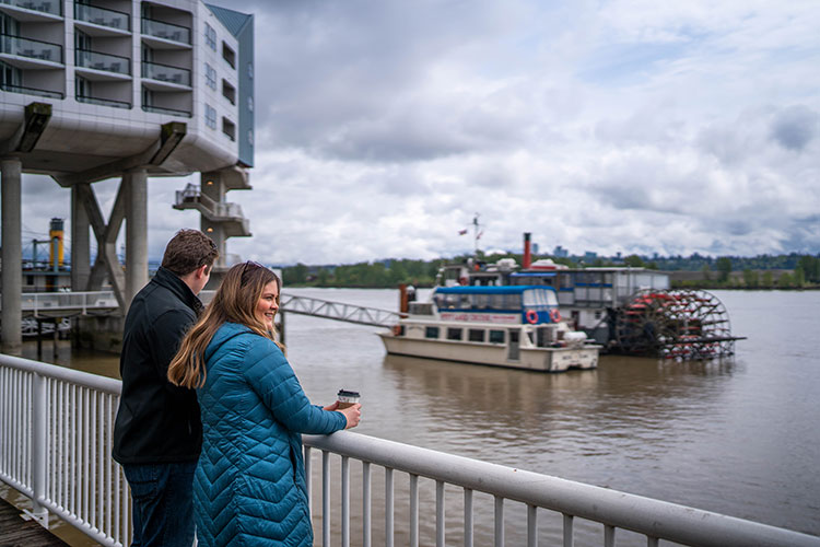 Couple standing on boardwalk next to water