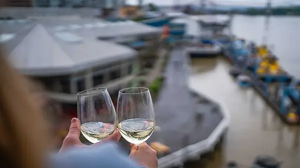 couple drinking wine on patio overlooking quay